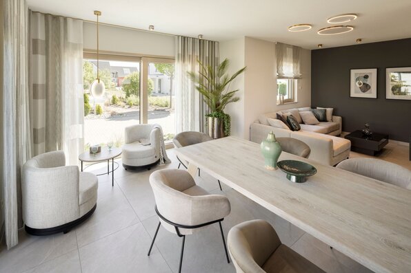 Helles Esszimmer im FingerHaus ARTIS 300 Musterhaus Nürnberg mit großem Esstisch, modernen Stühlen und Blick ins Wohnzimmer.
