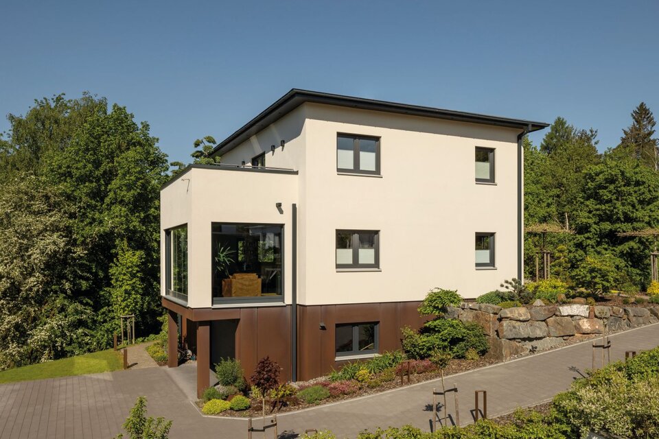 Modernes FingerHaus mit Flachdach, klarer Architektur und integrierter Garage, umgeben von Garten und Natur.