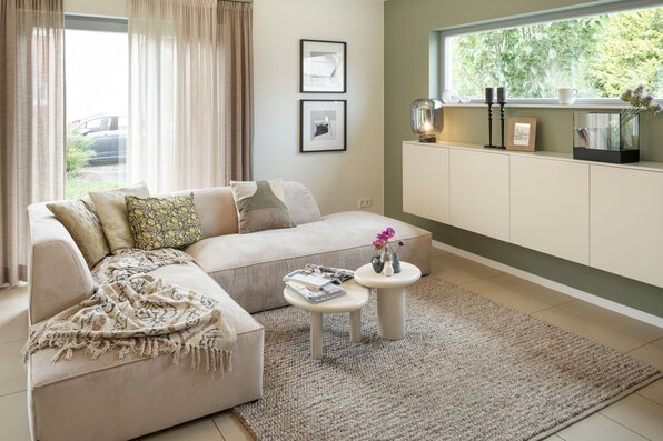 Gemütliches Wohnzimmer im frei geplanten FingerHaus Musterhaus Marburg mit heller Sofalandschaft, Couchtischen und stilvoller Fensterfront.