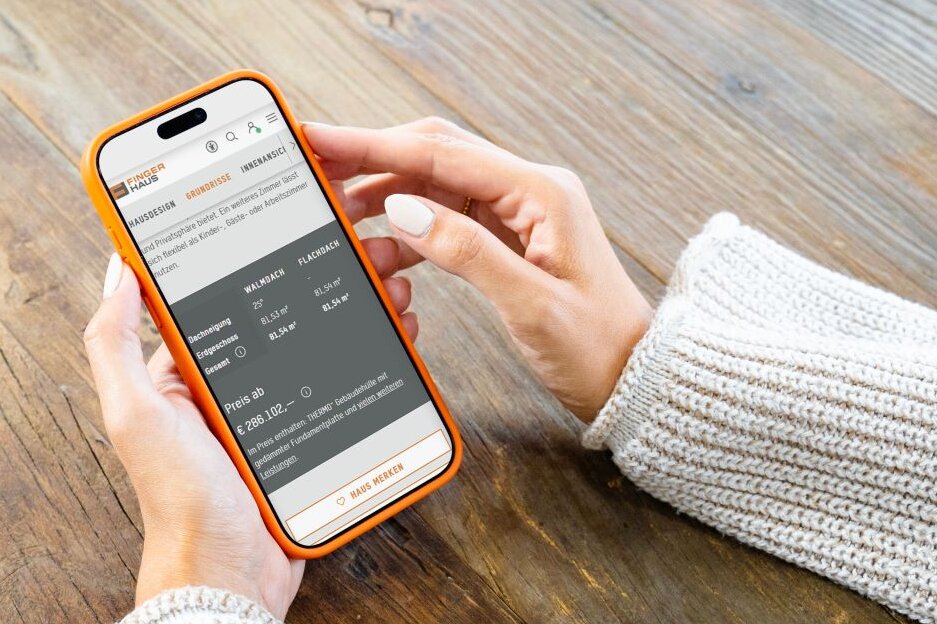 Person hält ein Smartphone mit dem FingerHaus+-Account in den Händen. Auf dem Display sind exklusive Inhalte und Einblicke für Bauinteressierte zu sehen.