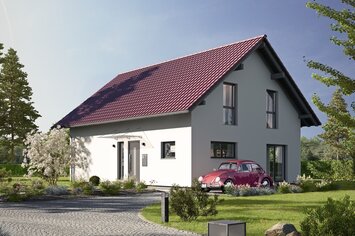 Fertighaus FingerHaus JUNO 402 mit heller Fassade, rotem Satteldach und gepflasterter Einfahrt mit Auto und Vorgarten bei Abendstimmung.