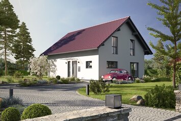 Fertighaus FingerHaus JUNO 402 mit heller Fassade, rotem Satteldach und gepflasterter Einfahrt mit Auto und Vorgarten bei Abendstimmung.