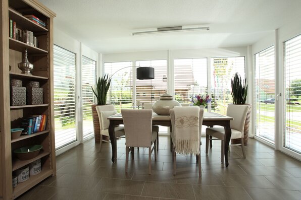 Helles Esszimmer im MEDLEY 310, Musterhaus Erfurt, mit großem Esstisch und bodentiefen Fenstern.