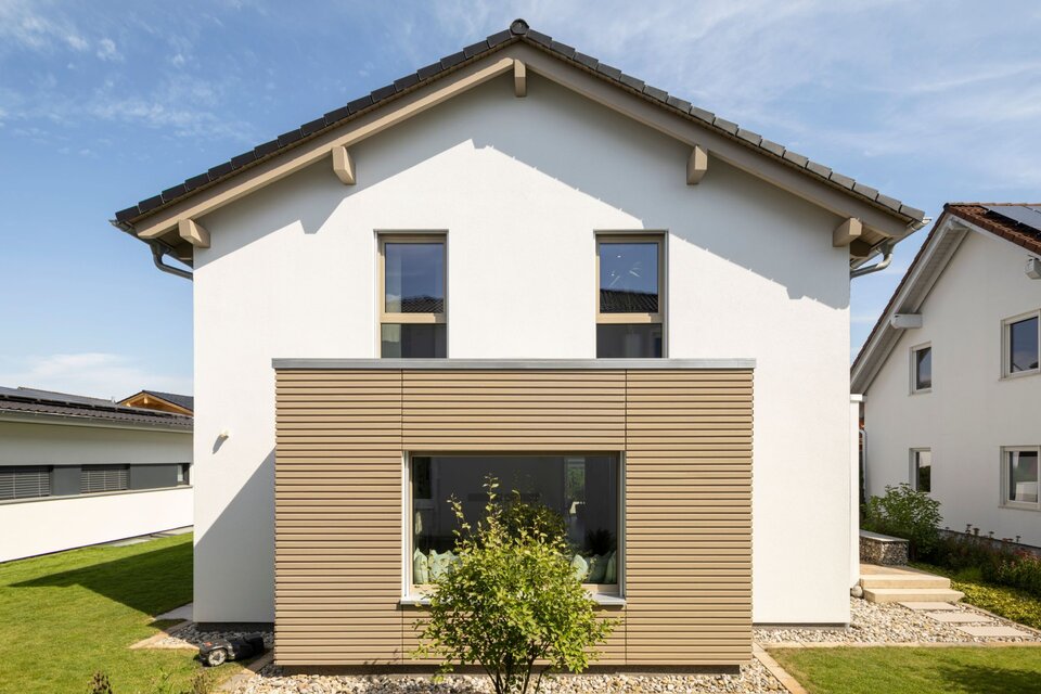 Außenansicht des Musterhauses MEDLEY 300 B in Poing mit moderner Fassadengestaltung in Weiß und Holzoptik.