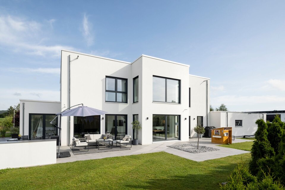 Modernes, frei geplantes FingerHaus mit kubischer Architektur, Flachdach und großer Terrasse im Garten.