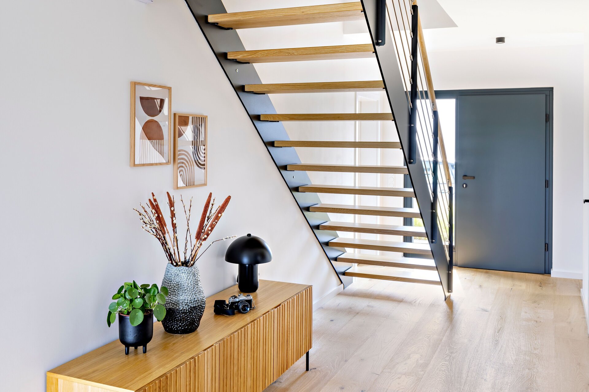 Frei geplantes FingerHaus mit moderner Holztreppe im Eingangsbereich und hellem Eichenparkett.