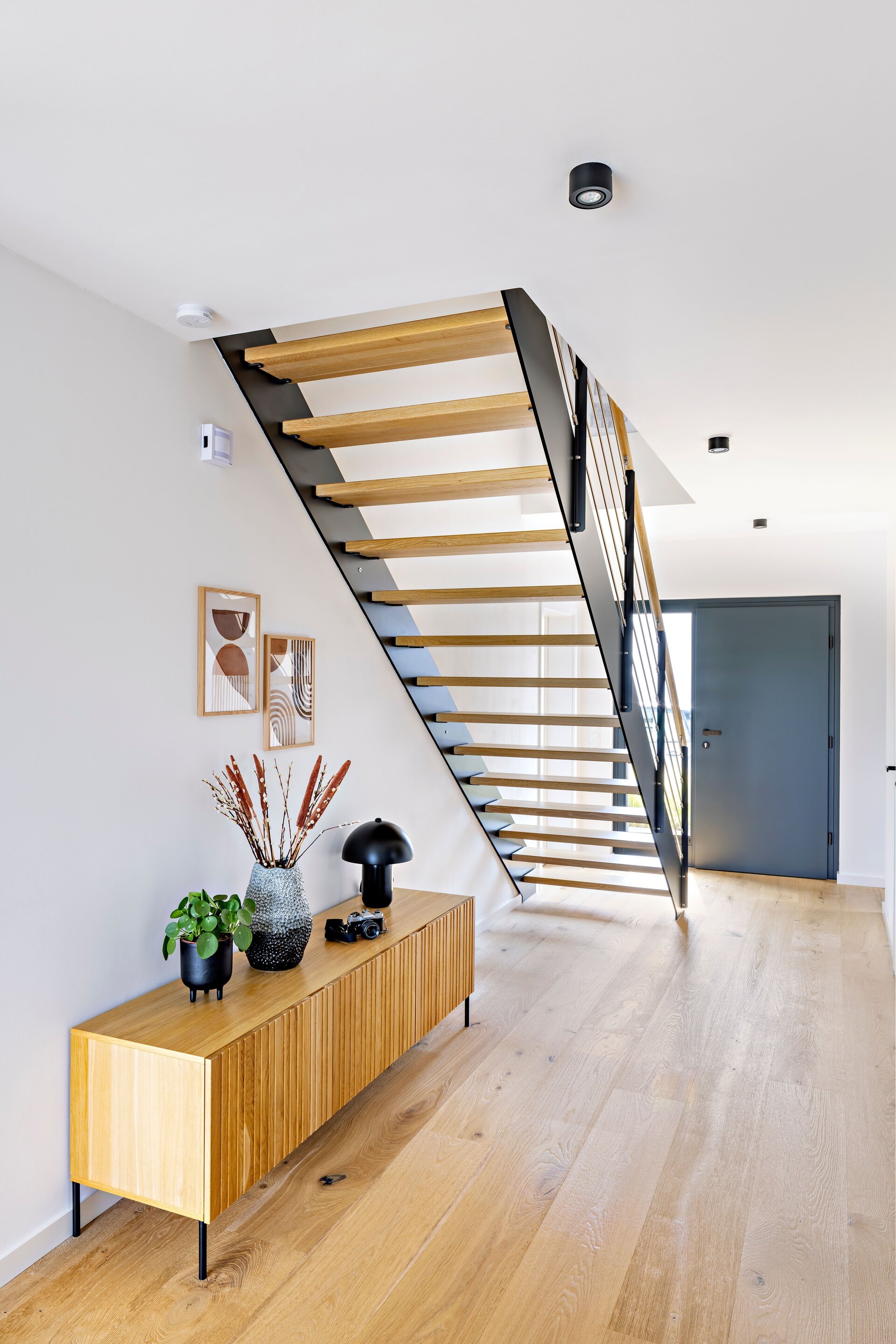 Frei geplantes FingerHaus mit moderner Holztreppe im Eingangsbereich und hellem Eichenparkett.
