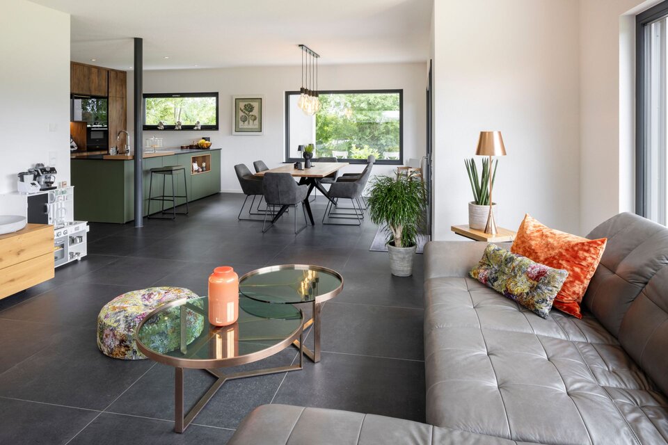 Offenes Wohnkonzept in einem FingerHaus mit modernem Wohnzimmer, Essbereich und angrenzender Küche in stilvollem Design.