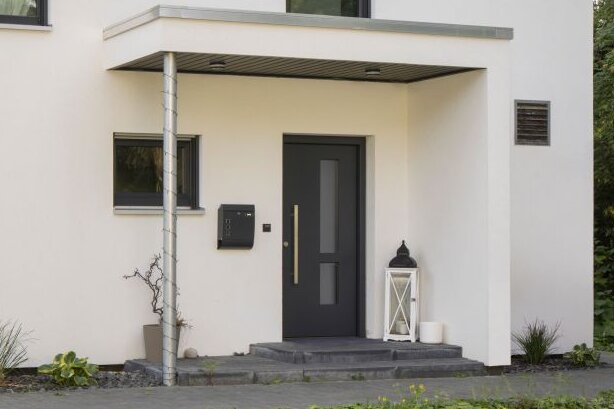 Modernes frei geplantes FingerHaus mit Satteldach, klarer Fassadengestaltung und gemütlicher Terrasse im Garten.