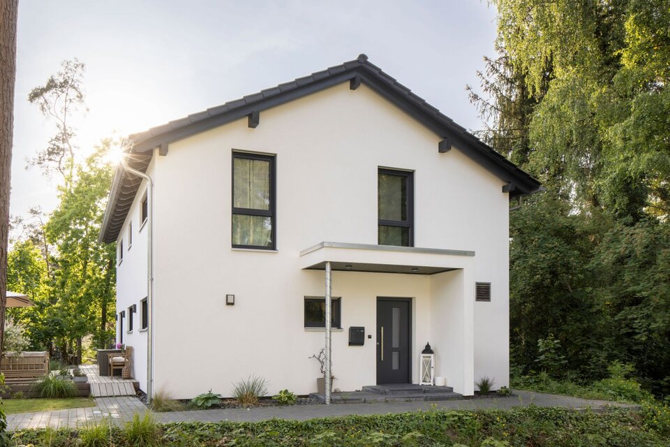 Modernes frei geplantes FingerHaus mit Satteldach, klarer Fassadengestaltung und gemütlicher Terrasse im Garten.