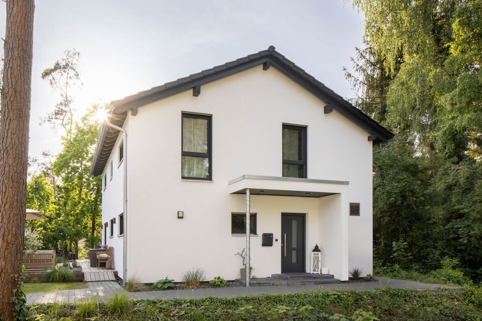 Modernes frei geplantes FingerHaus mit Satteldach, klarer Fassadengestaltung und gemütlicher Terrasse im Garten.