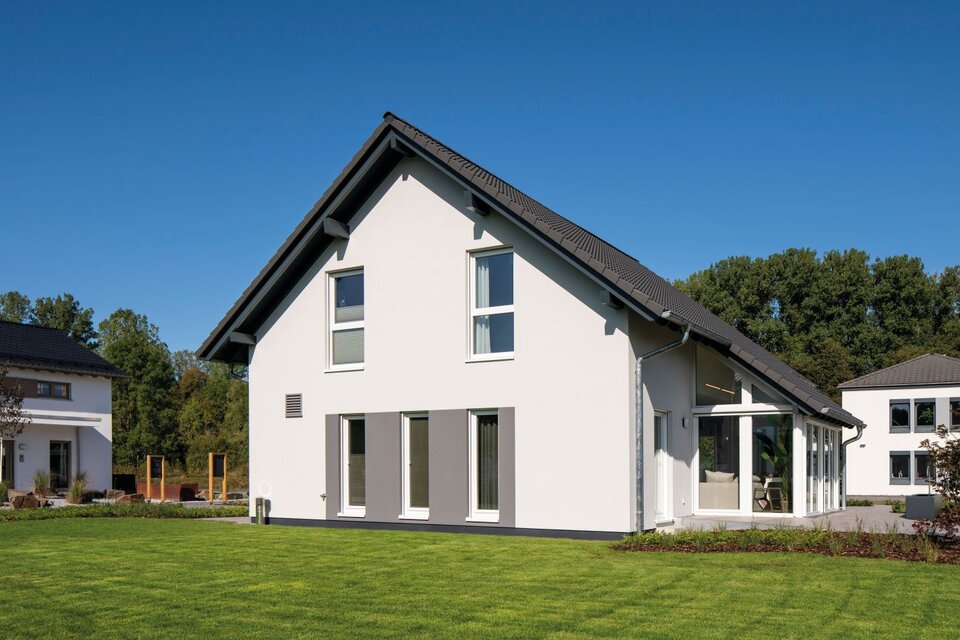 FingerHaus JUNO 402 Musterhaus Frankenberg – moderne Seitenansicht mit Wintergarten und großem Gartenbereich