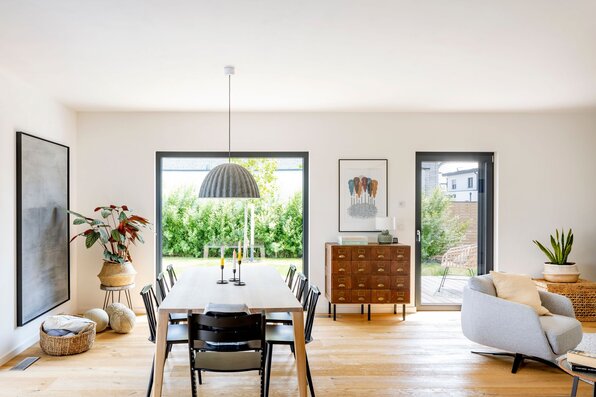 Helles Esszimmer in einem frei geplanten FingerHaus mit großem Holztisch, modernen Stühlen und stilvollem Design.