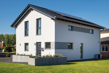 Modernes Einfamilienhaus UNO 2.0 im Musterhauspark Leipzig mit klarer Architektur, Satteldach und Gartenbereich.