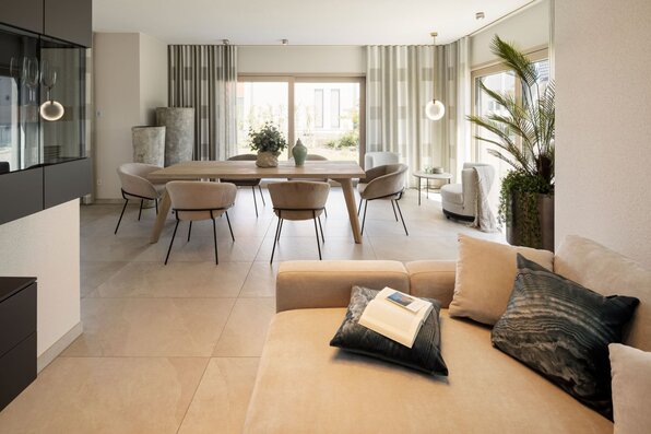 Gemütlicher Wohn- und Essbereich im FingerHaus ARTIS 300 Musterhaus Nürnberg mit heller Einrichtung, Esstisch und Sofa.