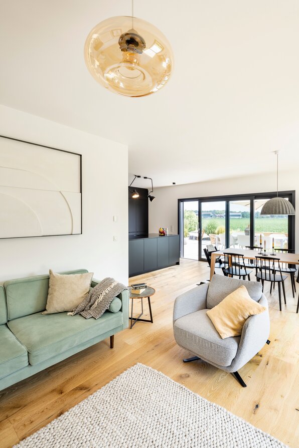 Modernes, frei geplantes FingerHaus mit offenem Wohn- und Essbereich, gemütlicher Sitzecke und großen Fenstern.