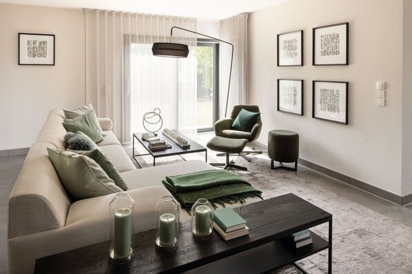 Helles Wohnzimmer im FingerHaus NEO 300 Musterhaus Hannover mit moderner Einrichtung, großem Sofa und gemütlichem Sessel.