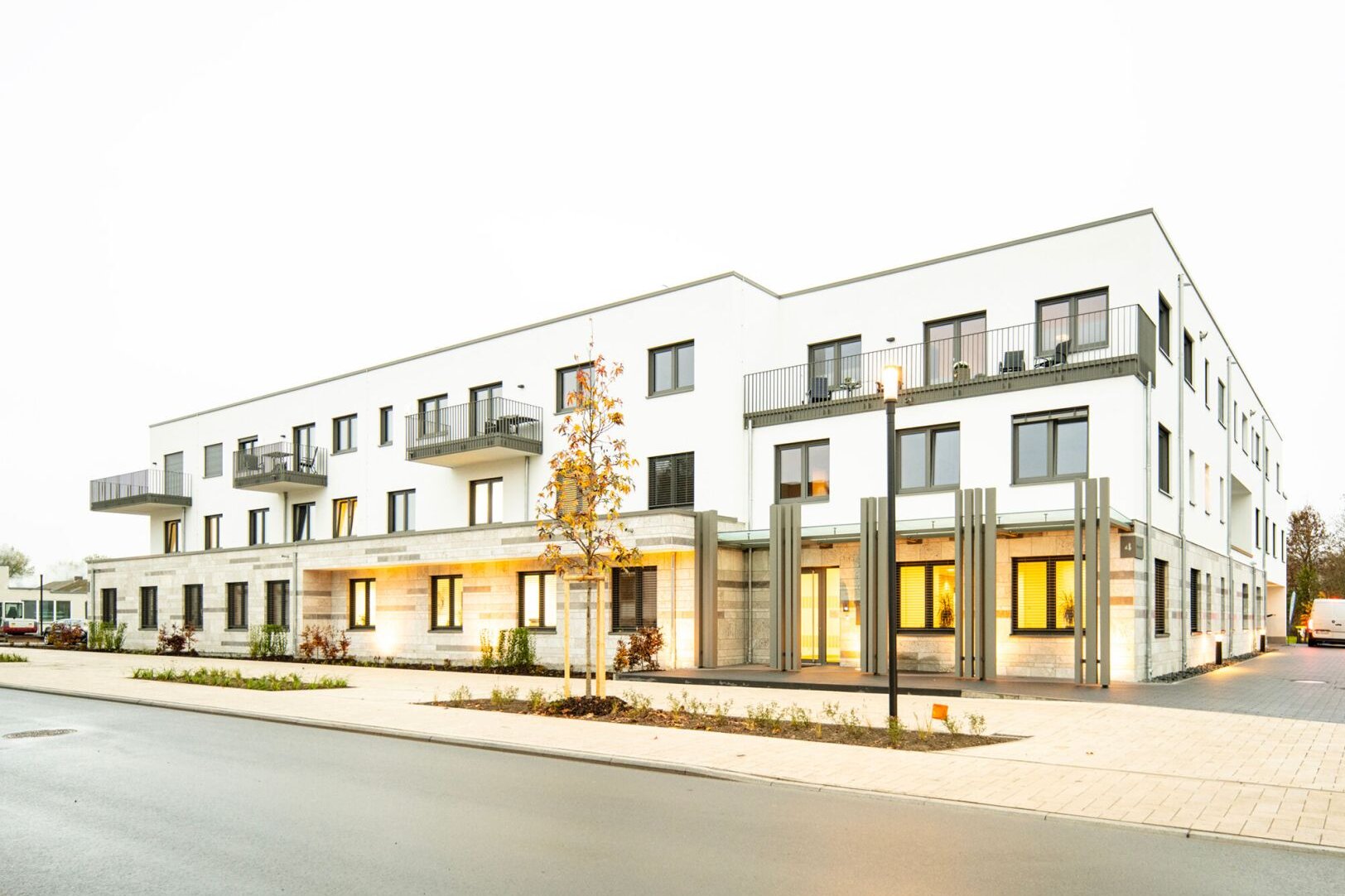 FingerHaus Geschossbau in der Jahnstraße in Frankenberg/Eder, modernes Mehrfamilienhaus mit Balkonen und beleuchteter Erdgeschosszone.