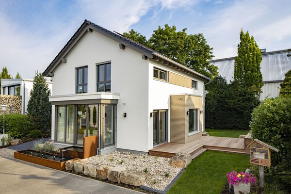 Modernes FingerHaus MEDLEY Musterhaus in Mannheim mit Holzakzenten, Wintergarten und gepflegtem Gartenbereich.