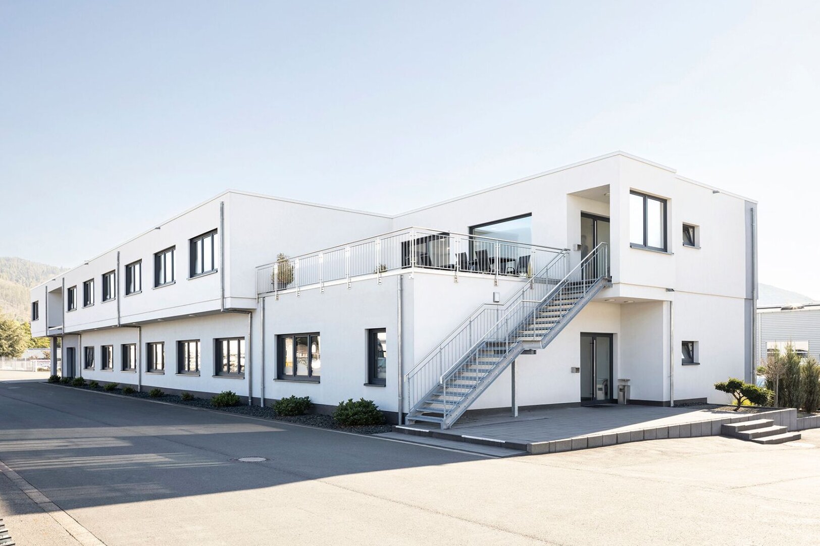 Modernes Firmengebäude mit klarer, zweigeschossiger Architektur und funktionaler Gestaltung, realisiert von FingerHaus im Bereich Objektbau.