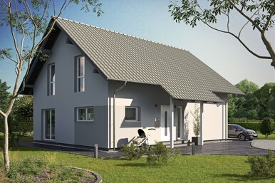 Fertighaus FingerHaus JUNO 402 mit hellgrauer Fassade, Satteldach und geschwungener Gartenanlage mit Rasen und Beeten im Sonnenschein.