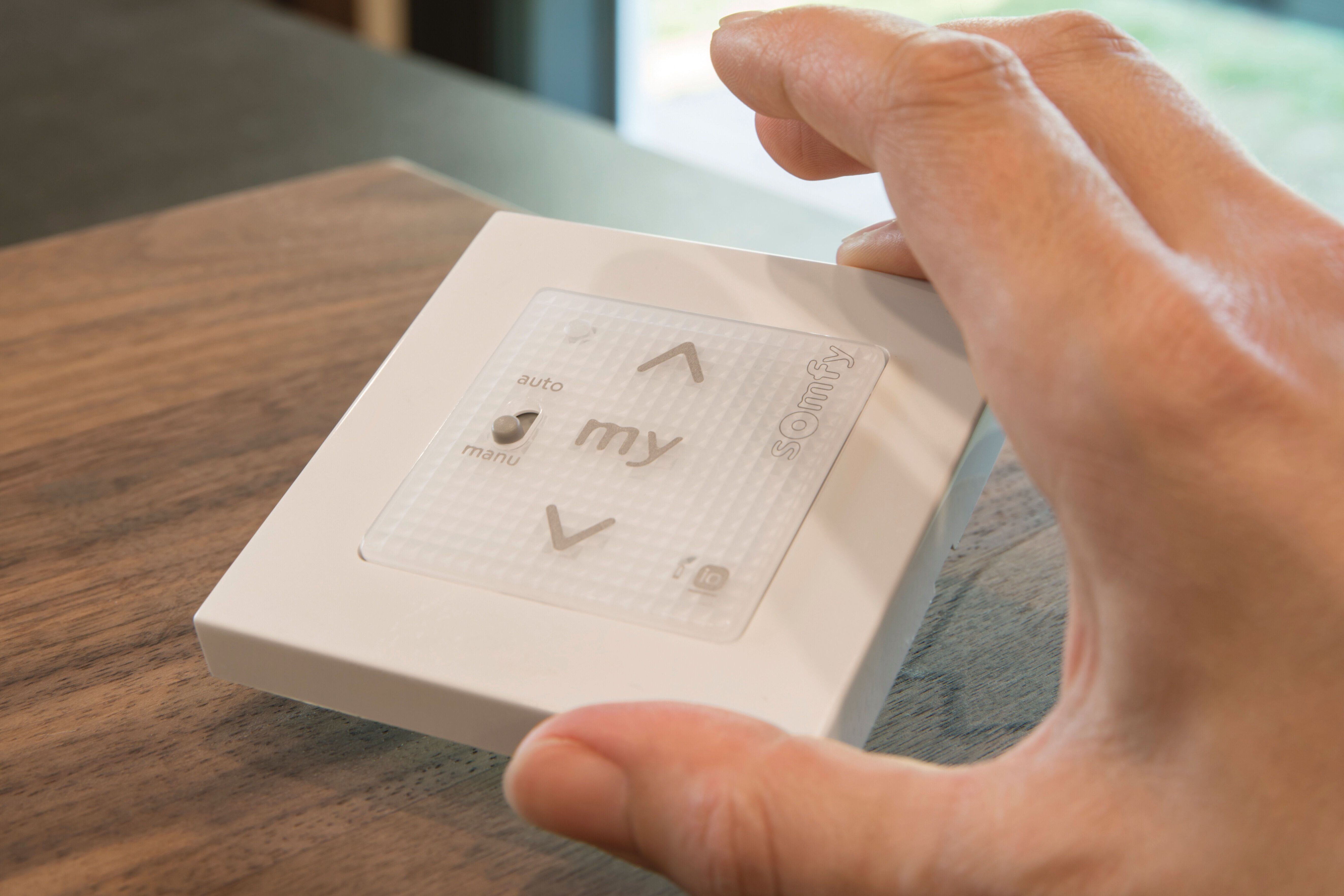 Hand betätigt moderne Steuerungseinheit für Jalousien im FingerHaus Musterhaus ALTERO in Gießen – Beispiel für intelligente Haustechnik.