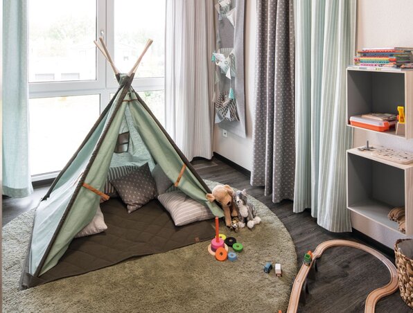 Kinderzimmer mit Spielzelt, Holzspielzeug und gemütlicher Einrichtung im Musterhaus UNO 2.0 Leipzig.