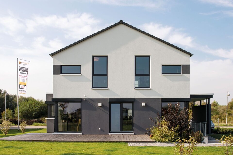 Rückansicht des FingerHaus MEDLEY 300 B im Musterhaus Berlin/Werder mit moderner Fassade in Grau-Weiß und großzügigem Garten.