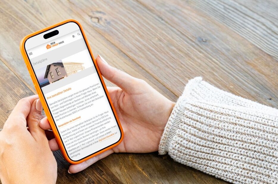 Person hält ein Smartphone mit dem FingerHaus Serviceportal in den Händen. Auf dem Display sind Detailpläne des Hauses dargestellt.