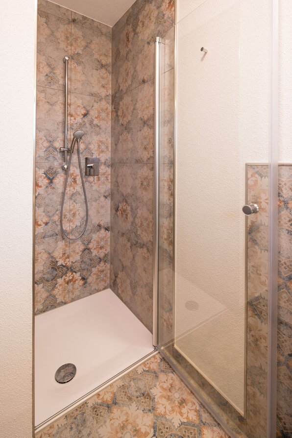 Moderne Dusche mit dekorativen Wandfliesen im Gäste-Bad des FingerHaus MEDLEY 300 B Musterhauses Berlin/Werder.