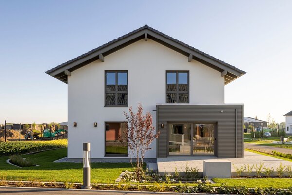 FingerHaus ARTIS 400 Musterhaus im Schwarzwald mit Satteldach, weißer Fassade, symmetrischen Fenstern und modernem Erker mit Holz-Elementen.
