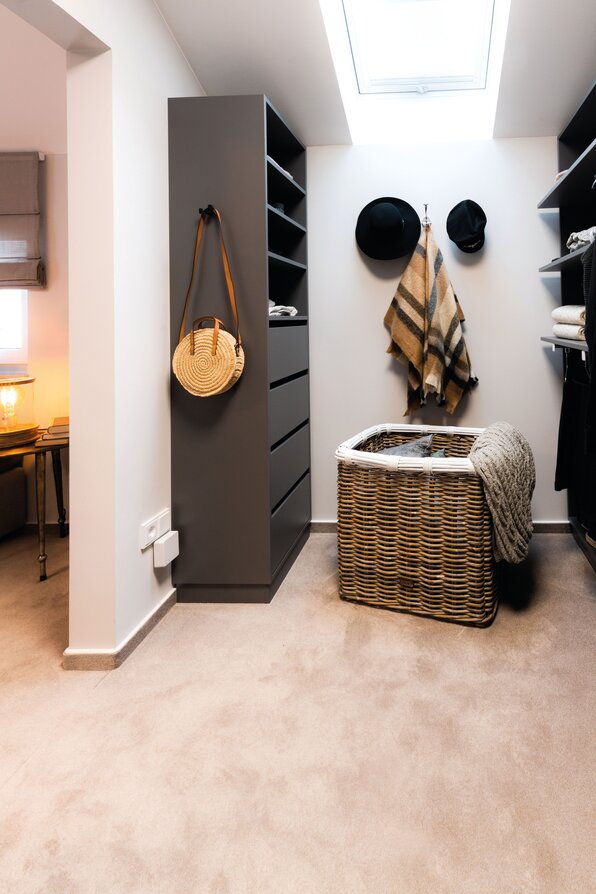 Moderner Ankleideraum mit viel Stauraum, Regalen und stilvoller Einrichtung im Musterhaus MEDLEY 300 B in Poing.