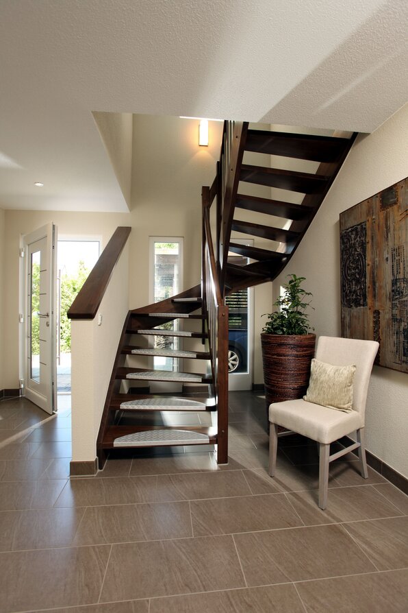 Moderne Holztreppe im MEDLEY 310, Musterhaus Erfurt, mit heller Diele und Dekoration.