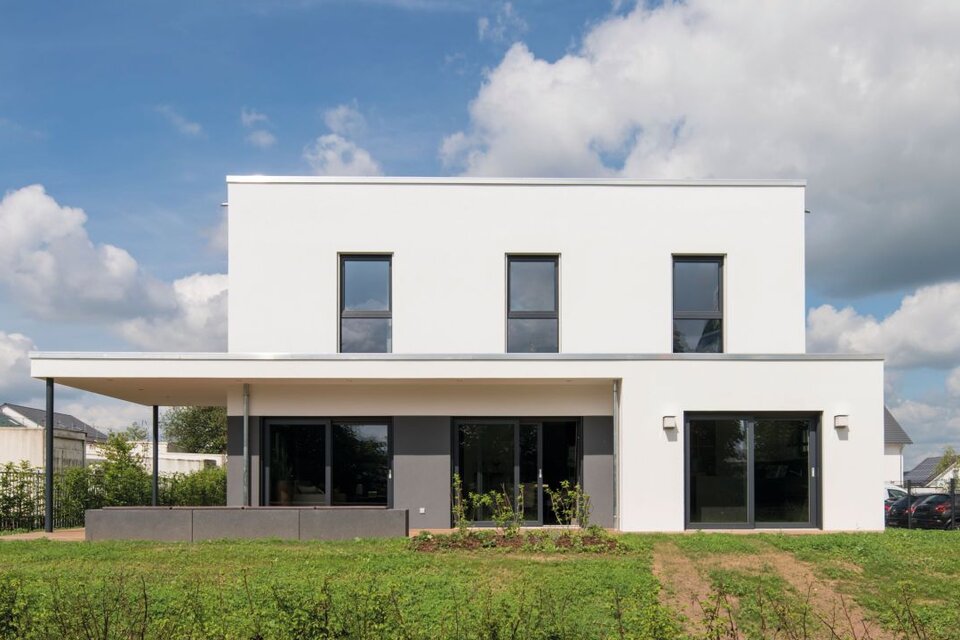 Frontansicht des Musterhauses ALTERO in Gießen mit Flachdach, klaren Linien und großflächigen Fenstern.