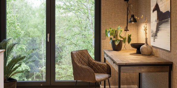 Frei geplantes FingerHaus mit stilvollem Arbeitsbereich am Fenster und modernem Mobiliar.
