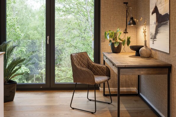 Frei geplantes FingerHaus mit stilvollem Arbeitsbereich am Fenster und modernem Mobiliar.