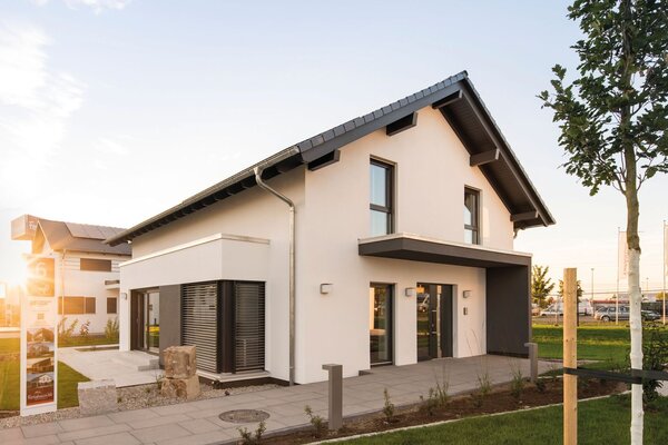 FingerHaus-Musterhaus NEO in Günzburg bei Abendsonne, modernes Einfamilienhaus mit Satteldach, Erker und gepflegtem Vorgarten im Musterhauspark.