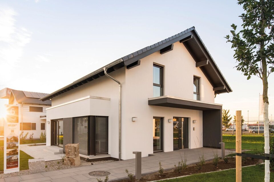 FingerHaus-Musterhaus NEO in Günzburg bei Abendsonne, modernes Einfamilienhaus mit Satteldach, Erker und gepflegtem Vorgarten im Musterhauspark.