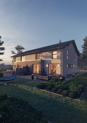 Haus FingerHaus DUO 258 bei Abendstimmung mit beleuchteter Terrasse, heller Fassade und gepflegtem Garten im warmen Sonnenuntergangslicht.