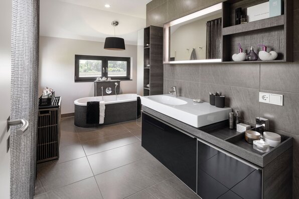 Luxuriöses Badezimmer im FingerHaus NEO 300 Musterhaus Hannover mit freistehender Badewanne, großem Waschtisch und modernen Fliesen.