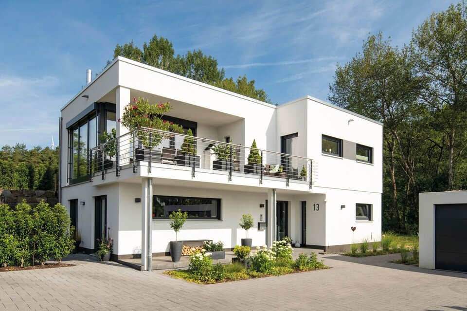 Modernes FingerHaus im Bauhausstil mit Flachdach, klaren Linien, großem Balkon, bodentiefen Fenstern und separater Garage, umgeben von Garten und Einfahrt.