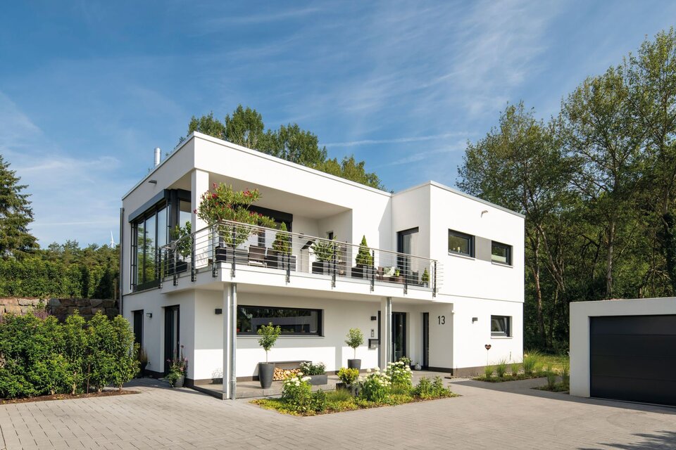Modernes FingerHaus im Bauhausstil mit Flachdach, klaren Linien, großem Balkon, bodentiefen Fenstern und separater Garage, umgeben von Garten und Einfahrt.