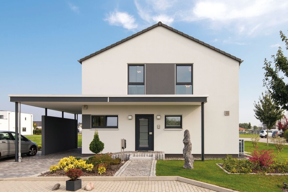 Eingangsbereich des FingerHaus MEDLEY 300 B im Musterhaus Berlin/Werder mit Carport, moderner Fassade und gepflegter Vorgartenanlage.