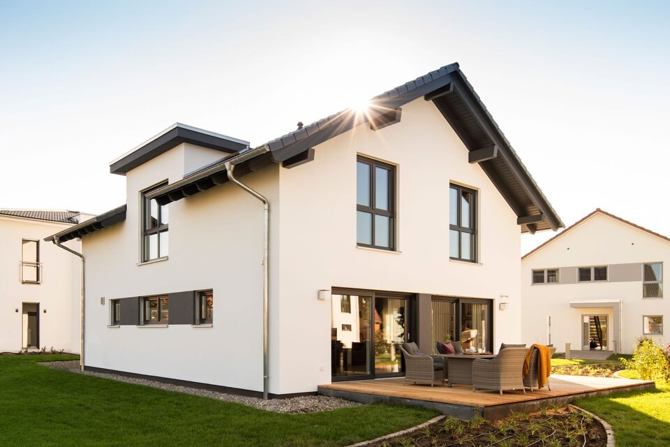 Modernes Fertighaus FingerHaus NEO im Musterhaus Günzburg mit heller Fassade, großen Fenstern und gemütlicher Terrasse.