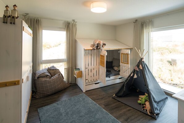 Kinderzimmer im Musterhaus MEDLEY 300 B in Kassel mit Spielhaus-Bett, Kuschelecke und Tipi-Zelt für kreative Abenteuer.