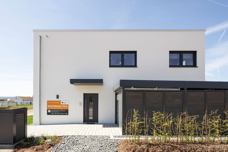 Eingangsbereich des Musterhauses TALO in Fulda mit moderner Fassadengestaltung und klarer Linienführung.