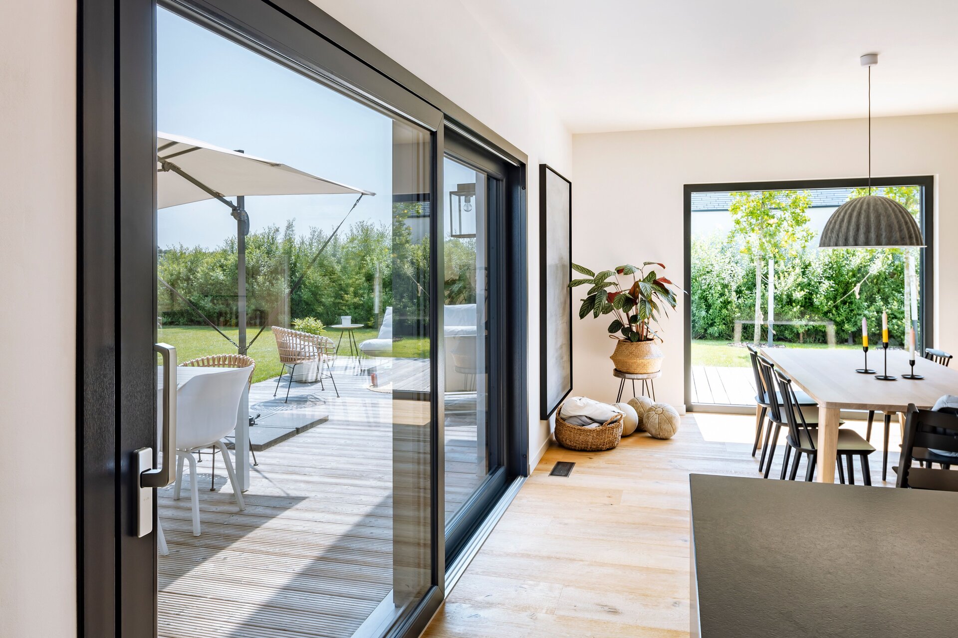 Frei geplantes FingerHaus mit moderner Schiebetür, hellem Essbereich und Zugang zur Terrasse.