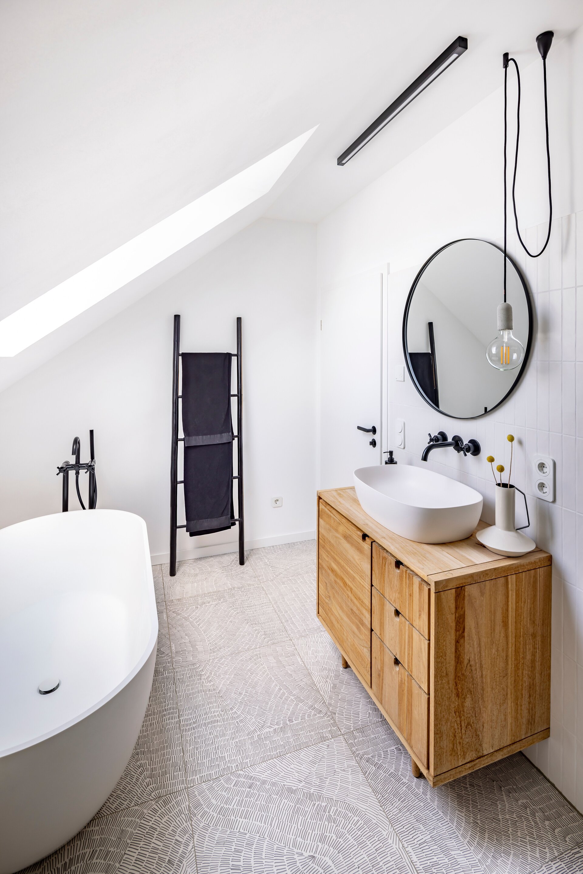 Modernes Bad in einem frei geplanten FingerHaus mit freistehender Badewanne, Holzwaschtisch und stilvollen Details.