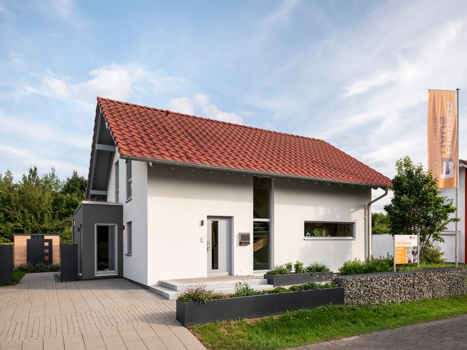 Frei geplantes FingerHaus Musterhaus in Marburg mit rotem Satteldach, moderner Fassade und einladendem Eingangsbereich.