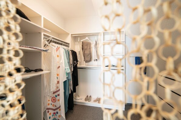 FingerHaus JUNO 402 Musterhaus Frankenberg – Ankleidezimmer mit offenen Regalsystemen und moderner Stauraumlösung